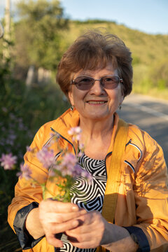 Elderly woman portrait with a bouquet of field flowers outdoor
