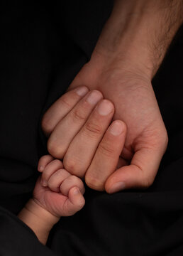 little baby and his father's hands