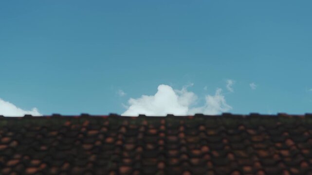 Beautiful motion of white clouds with blue sky in timelapse, isolated rooftop as foreground. 4K horizontal time lapse footage. Landscape concept