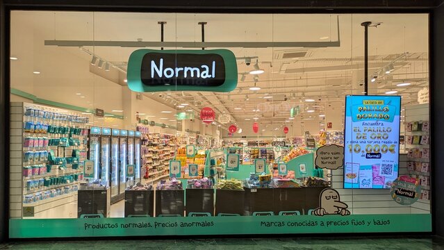 Fachada con escaparate de tienda Normal con personaje de publicidad y digital signage, en centro comercial Islazul de Madrid, Espa&ntilde;a, 13 de mayo de 2026