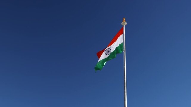 Indian flag flying high with blue sky background near Pangong lake Leh Ladakh, India. Indian flag waves in the kargil district Himalayas. Indian flag for Independence Day of India	