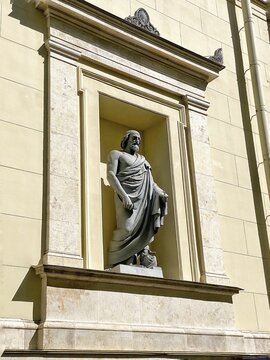 Classical stone statue in architectural niche illuminated by bright natural sunlight