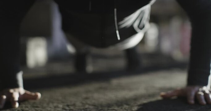 Person doing push up on floor in shallow focus