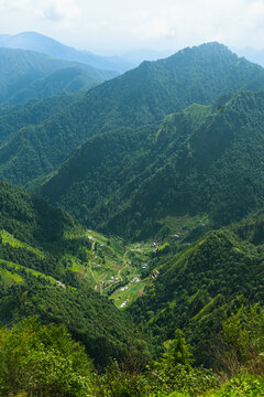 Panoramic View of Lush Mountain Landscape with Rural Village and Blue Sky in Uttarakhand