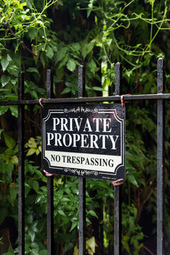 Private property no trespassing sign on a black metal fence