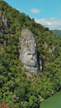 Aerial view of stone carved statue portrait of ancient dacian king Decebal. Sculpture near Danube River, Romania. Vertical video 4k