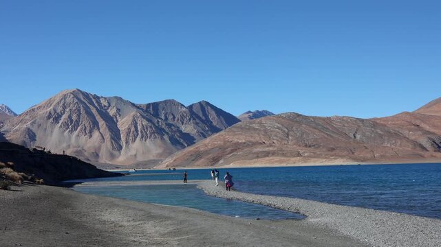 Scenic Pangong Tso lake at Leh Ladakh India with tourists. Lake extends from India to Tibet. Leh, Ladakh, Manali Jammu and Kashmir, India. 3 idiots move was shot here