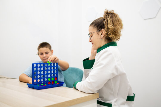 Female ENT doctor conducting hearing therapy with a child using an educational game.Concept of games for auditory ability.
