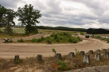 A panoramic view of the outdoor military training area surrounded by trees and open terrain. The site preserves the atmosphere of historical military exercises. © Fullip
