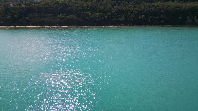 Aerial View of Turquoise Sea, Sandy Beach and Green Forest Coastline
