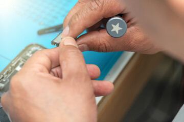 Fototapeta premium Technician repairing smartphone components on a workbench in electronics repair laboratory