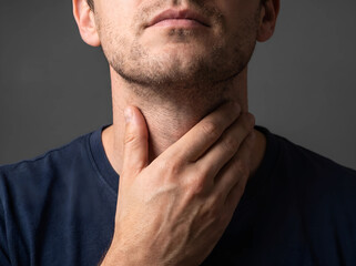 Fototapeta premium Man checking neck for thyroid enlargement or gland issues with swelling