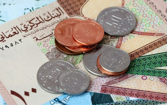 Omani rial money bills and coins on table. Oman cash of OMR currency close up