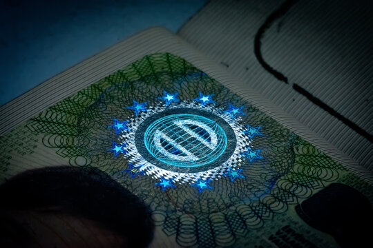 A close-up of the illuminated holographic emblem of the EU Schengen visa. The iridescent multicolor security hologram of the Schengen visa of the European Union countries. Macro photography.