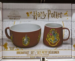 Fototapeta premium Set de tazas de desayuno de Harry Potter, con taza con el escudo de Hogwarts y cuenco con el escudo de Hufflepuff, en estante de juguetería Toy Planet en Madrid, España, 13 de mayo de 2026