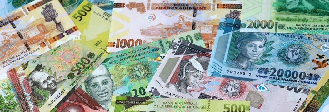 Guinean franc money banknotes bunch on table. Guinea bills of GNF currency close up