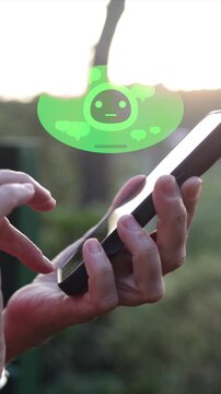 Human hand interacting with smartphone using an artificial intelligence chatbot, the animated bot floating above the device and responding to user queries with messages