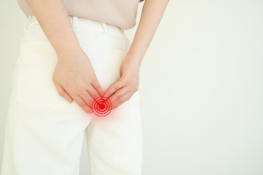 Woman suffering from anal pain and discomfort. Cause of pain include hemorrhoid, anal fissure, diarrhea, constipation or Crohn's disease. Gastrointestinal system concept.