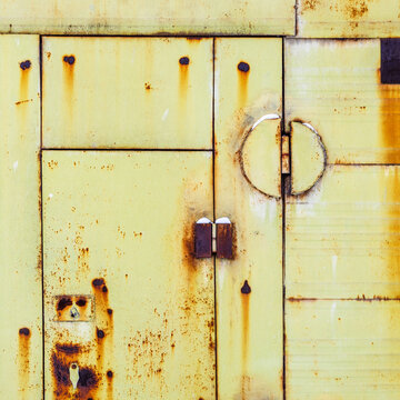 rusty yellow green painted metal shed doors