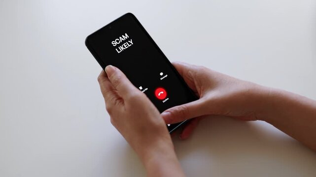 Woman holding smartphone with incoming scam call on screen.