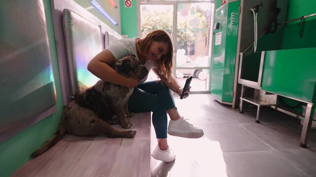 Woman taking a selfie with her pitbull at a grooming salon