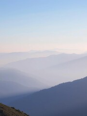 Fototapeta premium Silent morning mist shrouds tranquil mountain peaks in soft blue haze, stillness, morning