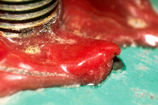 Detailed Macro Shot of a Glossy Red Surface Next to Textured Metallic Elements