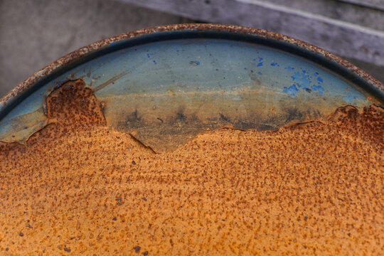 Heavily Corroded Blue Metal Drum with Peeling Paint and Orange Rust