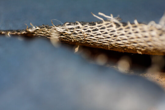 Extreme Close up of Rough Woven Fabric with Frayed Fibers and Grid Pattern
