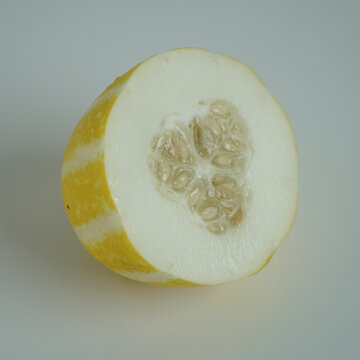 Freshly Sliced Yellow Lemon Cucumber on a White Background with Seeds Visible