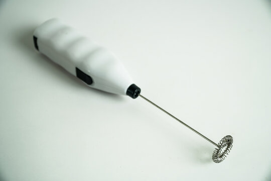 White Handheld Battery Operated Milk Frother with Whisk on a Clean Background