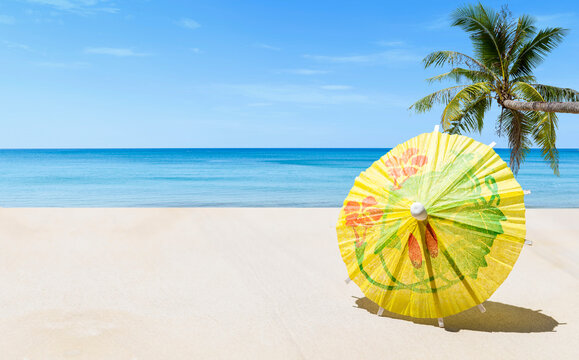 Yellow paper umbrella on tropical beach background, summer season concept, outdoor day light