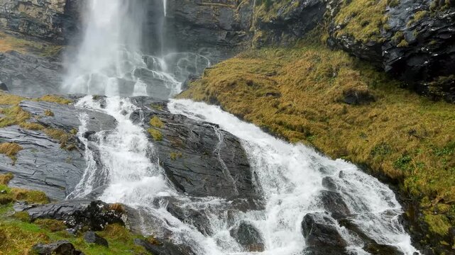 Fallbach mountain waterfall pouring over dark rock. Autumn in Austria.