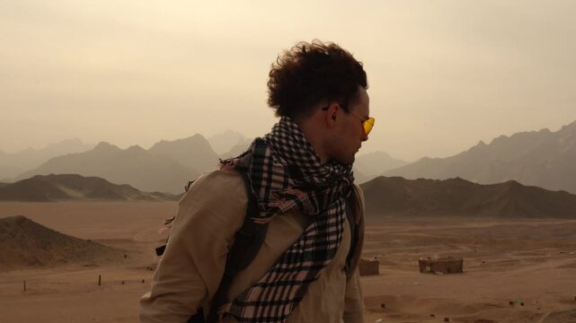 Travel photographer holding camera in Egypt Hurghada desert mountains sunset view.
