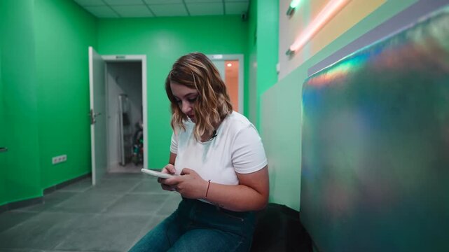 Woman with a lavalier mic reading a script off her phone for an interview