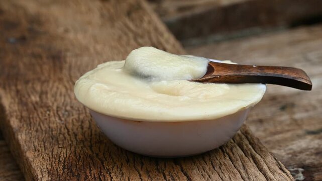 pure OR desi ghee also known as clarified liquid butter. pure OR desi ghee in bowls on an old wooden table.