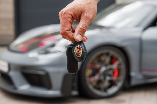 Ljubljana, Slovenia - 18 May 2026: A hand holds a Porsche GT4 RS car key near the vehicle showing the sports car lifestyle and enthusiasm for performance driving.