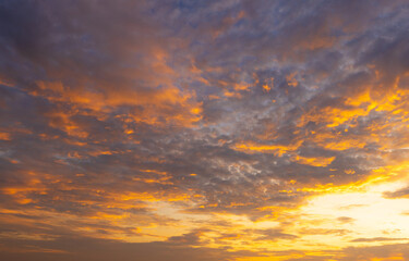 Fototapeta premium Dramatic Golden Hour Sunset Sky with Colorful Clouds,A breathtaking view of a vibrant sunset sky filled with dramatic clouds illuminated by golden sunlight, creating a stunning contrast between warm.