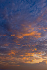 Obraz premium Dramatic Golden Hour Sunset Sky with Colorful Clouds,A breathtaking view of a vibrant sunset sky filled with dramatic clouds illuminated by golden sunlight, creating a stunning contrast between warm.