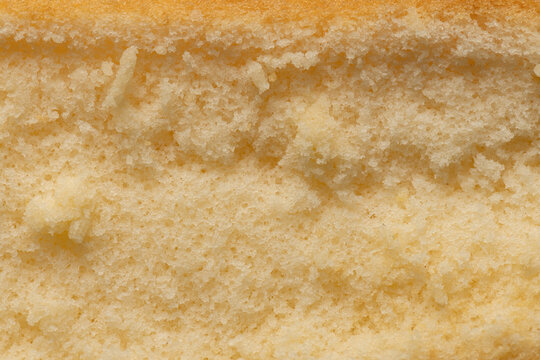 Close-up texture of soft yellow chiffon cake,A macro view showing the fine, porous, and fluffy texture of a freshly baked golden chiffon sponge cake.