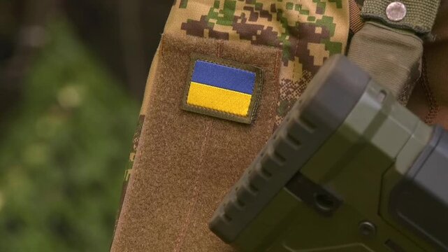 Close-up of the Ukrainian flag patch on a soldier's uniform sleeve. Symbol of national identity, military service, and the Armed Forces of Ukraine during the defense of the country's sovereignty and