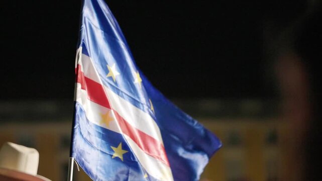 Flag of Cape Verde held high by a crowd during the football championship celebration in Lisbon, showcasing vibrant colors and symbols of national pride