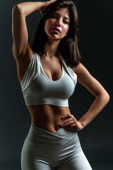 Fototapeta premium fitness woman in sensual sportswear posing confidently in studio, athletic female model showcasing modern activewear in studio portrait, confident sporty woman wearing fashionable fitness apparel 