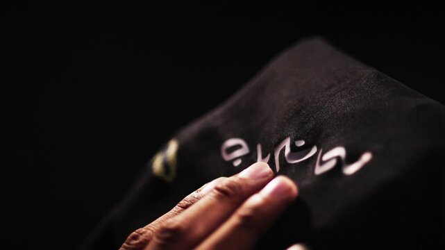 Close Up of Hand Holding Traditional Lontara Script Fabric