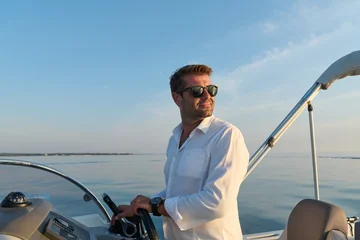 Man Steering Motorboat Near Umag At Sunset Wearing Sunglasses And White Shirt On Calm Sea © .shock