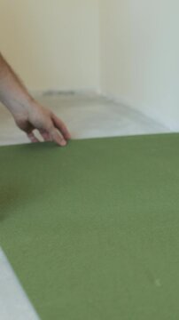 Vertical video Laying underlay for the laminate flooring. Preparatory work before laying a laminate board. Laying a polypropylene substrate under the laminate. Renovation of a new house.