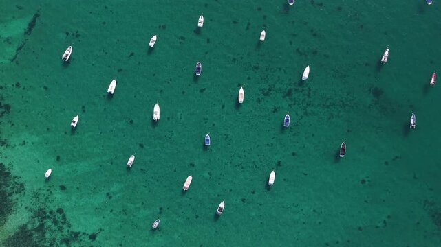 Coastal landscape of Portinho da Arr&aacute;bida in Portugal with boats anchored on the calm sea.
4K high quality cinematic aerial footage.