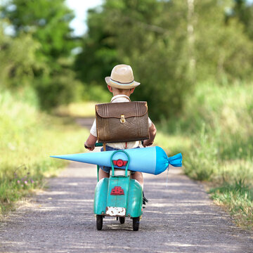little boy with school cone and vintage scooter on his first day of school