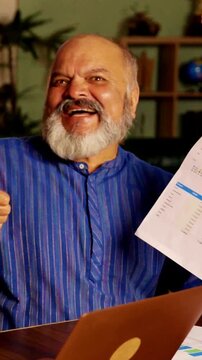 Asian Indian senior couple sharing joy and happiness in their modern home after  withdrawing cash from the bank, celebrating their financial success