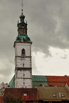 The Saint Jakob parish church belfry (Zupnijska Cerkev sv.Jakoba) jutting from the temple's roofs under a cloudy autumn sky. Skofja Loka-Slovenia-141